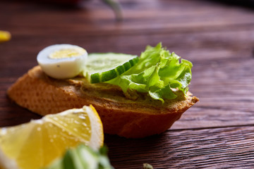 Breakfast sandwich with homemade paste, vegetables and fresh greens, shallow depth of field