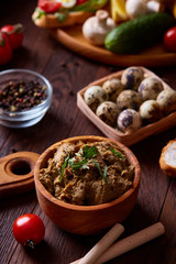 Paste from chicken liver with vegetables and quail eggs, shallow depth of field, close-up.