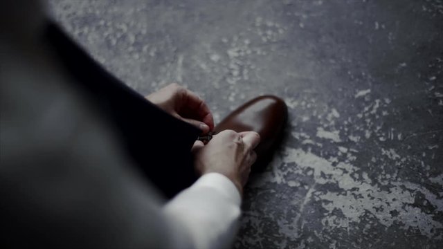 The man wears shoes. Tie the laces on the shoes. Men's style. Professions. To prepare for work, to the meeting.