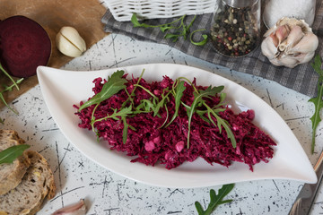Tzatziky from red beet and cottage cheese. Decorated with fresh arugula
