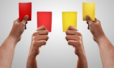 Set of hands holding red and yellow card