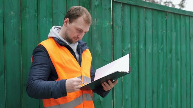 Engineer builder on the construction site takes notes on the drawings