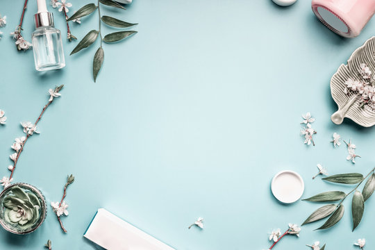 Facial Cosmetic Products, Leaves And Cherry Blossom On Blue Table