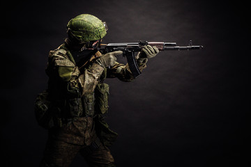 russian special forces soldier with rifle on dark background. army, military and people concept
