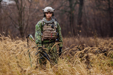 soldier with rifle in full gear. Military man on the background of nature.