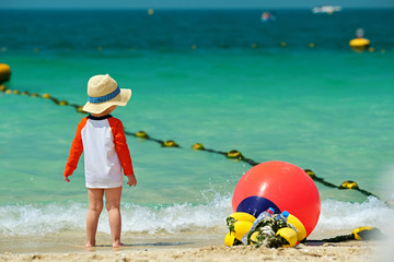 Two year old toddler boy walking on beach