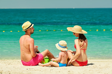 Family on beach. Toddler playing with mother and father.