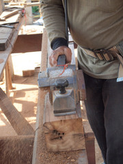 carpenter working with plane on wooden background