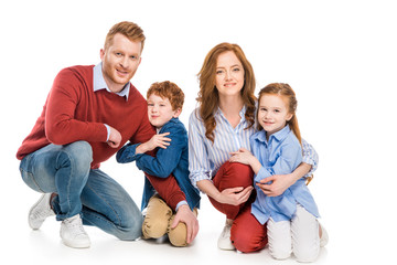 happy parents with adorable little kids smiling at camera isolated on white