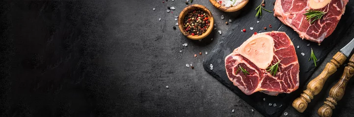 Photo sur Plexiglas Viande Steak de boeuf cru osso bucco sur fond noir. Viande marbrée.