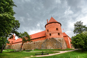 Trakai, Lithuania - August 15, 2017: Landscape of Trakai Island Castle, lake and wooden bridge, Lithuania. Trakai Island Castle and bright blue dramatic sky with clouds. 