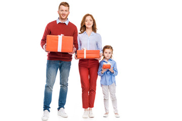 Fototapeta premium happy red haired family holding presents and smiling at camera isolated on white