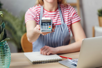 Photo of florist with calculator at table with laptop