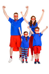 Fototapeta na wymiar happy super family in costumes raising hands and smiling at camera isolated on white