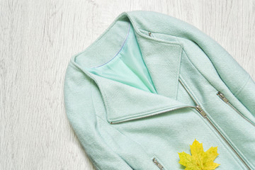 Mint jacket and maple leaf. Fashionable concept