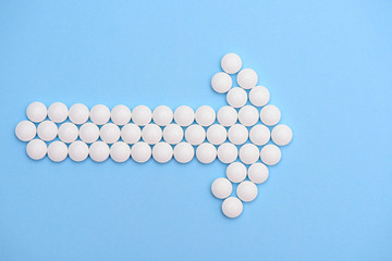 white pills in the shape of an arrow on a blue background