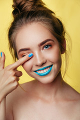 beauty art portrait of white young smiling girl in pastel tones blue caramel makeup. Vertical photo