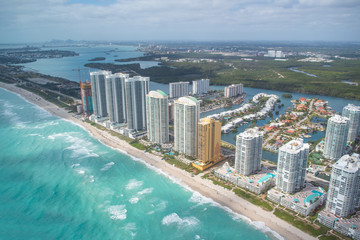 North Miami Beach buildings as seen from helicopter, Florida. Skyscrapers along the ocean, aerial view.