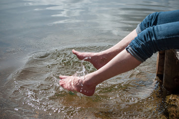 closeup of man trenching his feet in the water of a lake