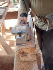 carpenter working with plane on wooden background