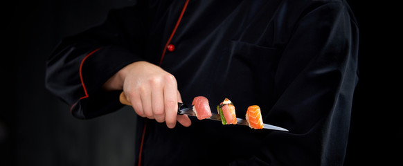 Sushi served on japanese knife in chef hand