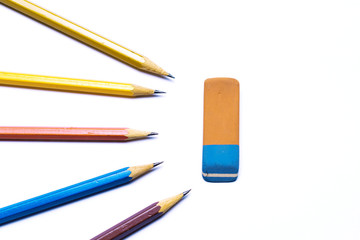 Eraser surrounded by sharp pencils. Isolated on white background. Metaphor of special or different children. Concept of the problem of adoption and socialization of people with disabilities