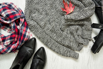 Gray warm sweater. Red maple leaf. Checkered scarf and boots. Fashionable concept