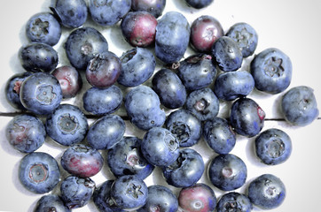 Some blueberries on a white wooden table in a rustic kitchen.