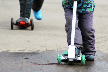 Children riding a scooter, feet
