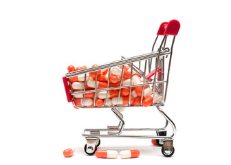Pills and shopping cart on white background : economy concept