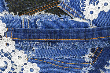 Openwork fabric lace on  Ripped Destroyed torn denim background