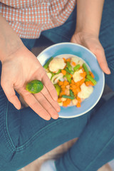 Girl with a plate of vegetables in hands. Healthy eating concept. Proper nutrition. Vegetarian food. Vegans food. Toned image.