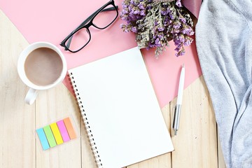 Business, planning, spring or summer concept : Top view or flat lay of open notebook paper, bouquet of flowers, knitted sweater and coffee cup on desk table with copy space ready for adding or mock up
