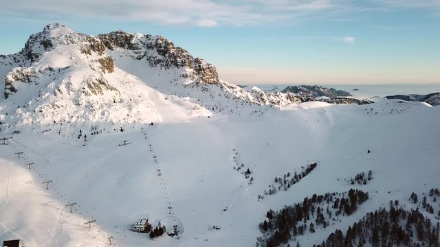 Drone flying over Piani di Bobbio near Lake Como, Northern Italy. Aerial view of the Italian Alps seen from the sky, mountains covered with snow and ski resort