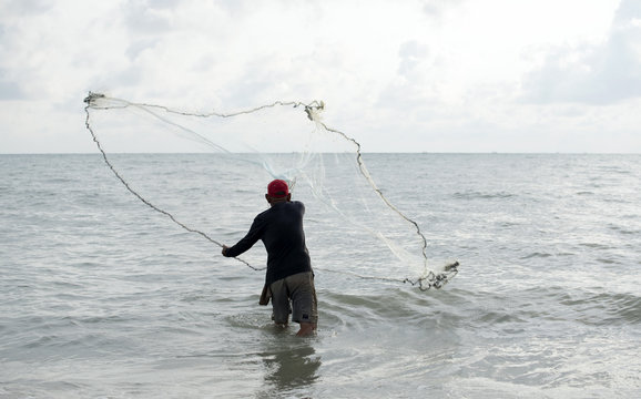 The fisherman cast a net the sea in the morning, at sunrise, Songkhla province, Thailand country