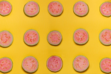 top view of slices of pink guava on yellow background