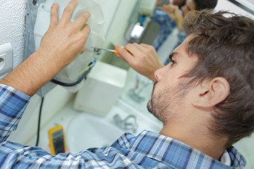 Fototapeta premium tradesman fixing electrical issue with hand dryer