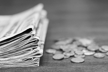 News and finance. Folded newspapers and stacked coins on table. Concept for business and financing....