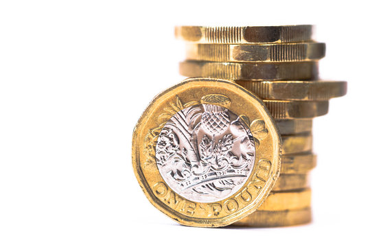 Stack of British Pound coins with one coin stood up at front