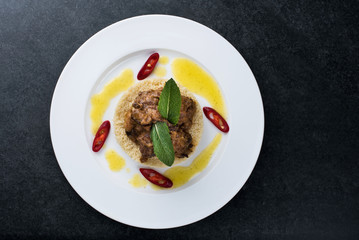Delicious cooked couscous with meat on a white plate