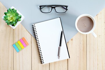 Still life, business, office supplies, planning or education concept : Top view or flat lay of open notebook with blank pages and coffee cup on office table, ready for adding or mock up