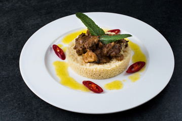 Delicious cooked couscous with meat on a white plate