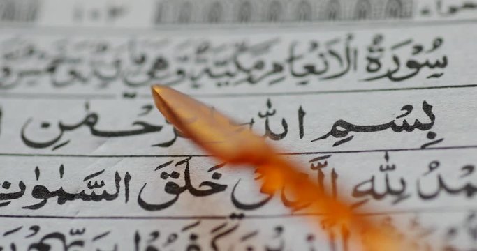 Macro shot of somebody reading Koran and using pointer stick for pointing the letters. Shot in 4k resolution
