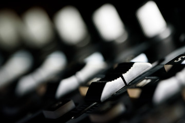 Macro close up of audio studio mixer volume level sliders and dials short depth of field selective focus
