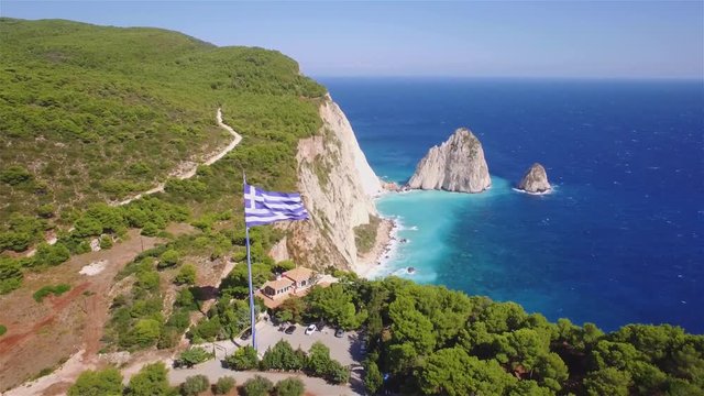 4K aerial view of Greek biggest national flag waving in the sky in Keri in Zakynthos (Zante) island in Greece