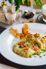 Scramble of eggs and bacon on a white plate