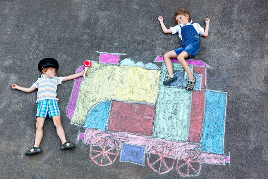 Two little kids boys having fun with train chalks picture