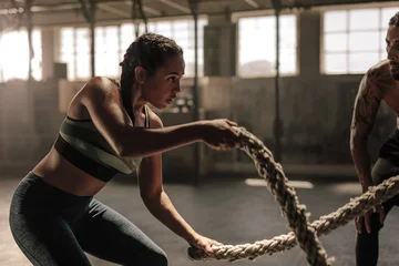 Photo sur Plexiglas Fitness Femme faisant de la corde de combat à la salle de sport