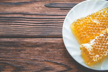 honey in honeycombs on a white plate 