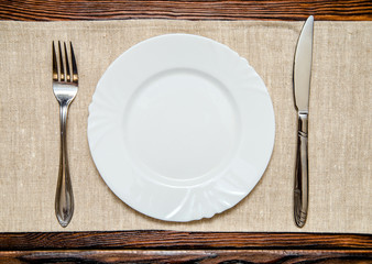 Cutlery lying on a brown wooden background 